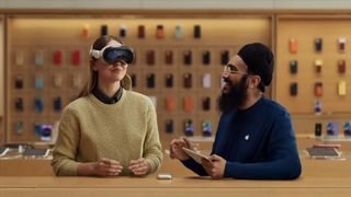 أحد موظفي Apple Store يوضح للعميل كيفية استخدام سماعة رأس Vision Pro.